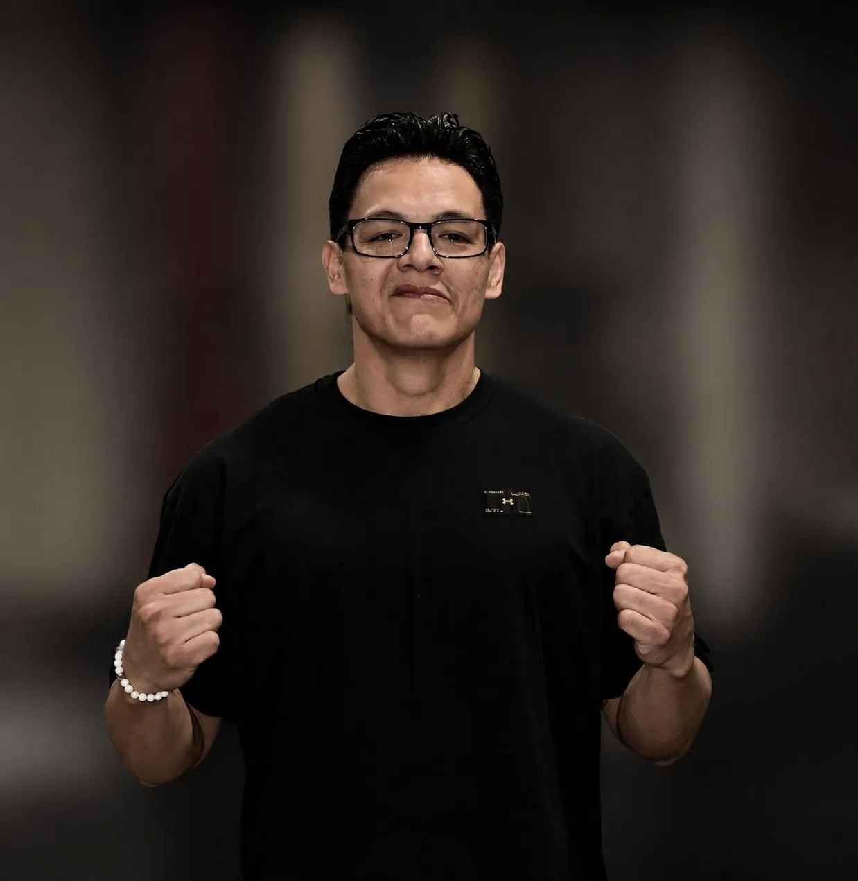 Coach Adam Toto, fists raised, in the gym
